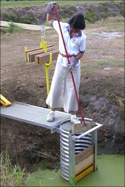Figure 3. Tools needed for safe operation of a riser-board structure include gloves and long-handled tools (such as modified ice tongs) for removing/inserting boards. Always wear gloves when working around riser-board structures.